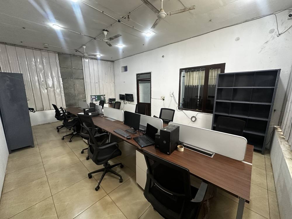 Wide view of the office with a long row of desks and chairs